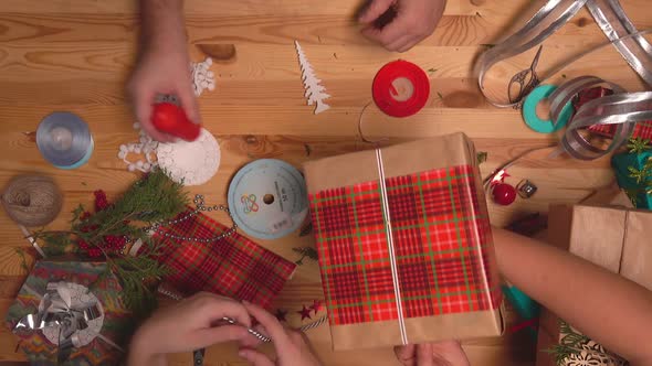 Top View of the Multiple Adult Hands Decorating Gifts for Christmas Celebrations