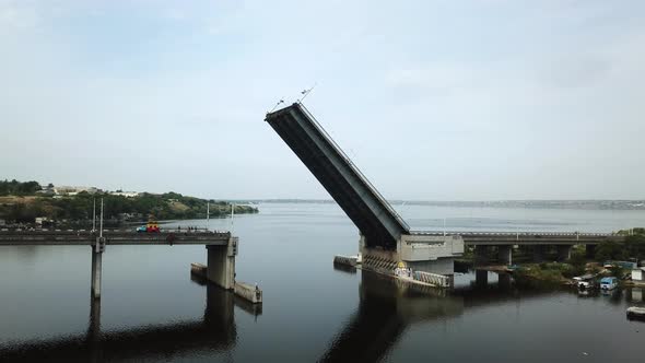 Fly by drone of a raised bridge for the passage of military carables along the river.