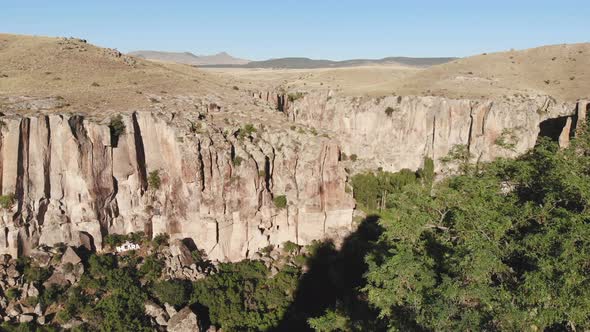 Aerial Deep Long Rift Canyon with Cleft Steep Rock Walls and High Cliff Gorge