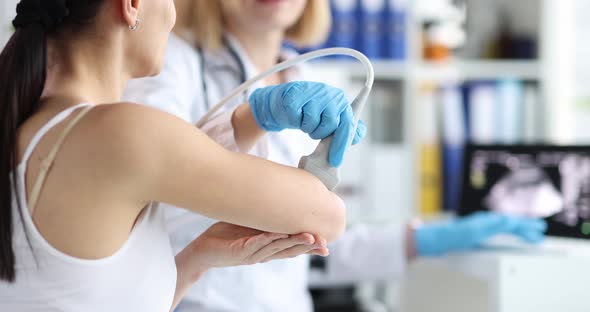 Doctor Conducting Ultrasound Examination of Elbow Joint in Clinic Closeup