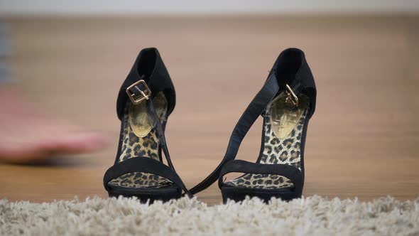 Close-up of Black Female High Heel Shoes Standing on the Floor As Caucasian Male Feet Coming at