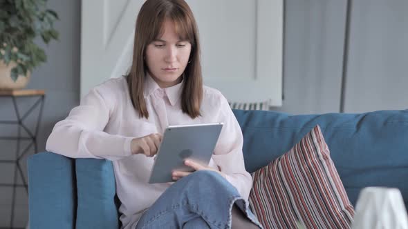 Casual Girl Using Tablet While Sitting on Couch