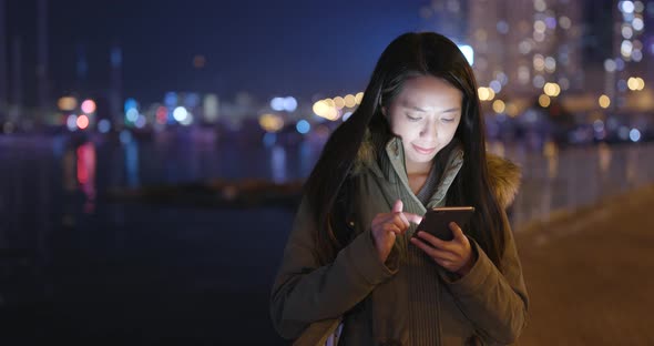 Asian woman use of smart phone in city at night