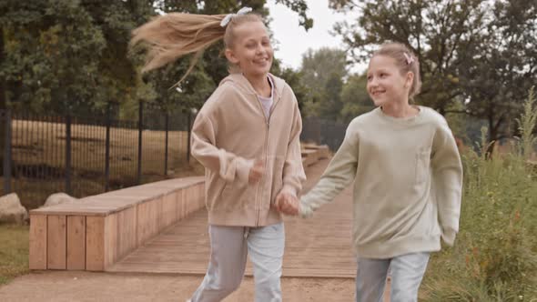 Girls Running Holding Hands at Park