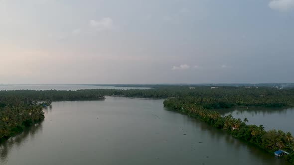 Beautiful aerial shot of a backwater canal, sunset,coconut trees ,water transportation,clouds,Blue S