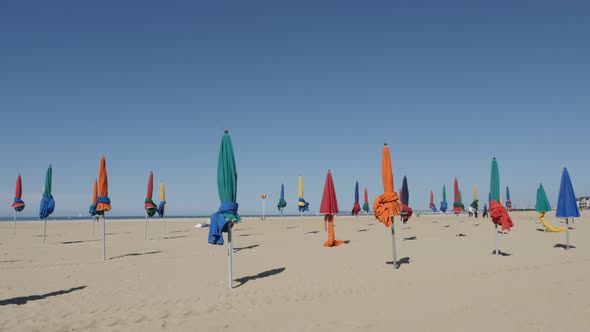 DEAUVILLE, FRANCE - SEPTEMBER 2016 Slow tilt of famous film festival city beach with colorful paraso