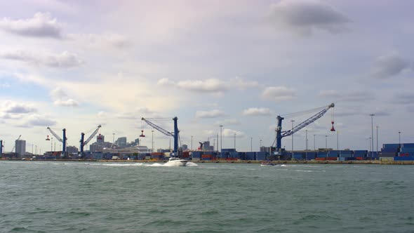 Cargo cranes and boats in the port alt