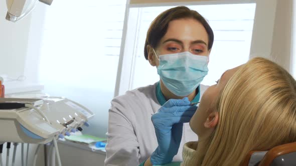 Female Dentist Working, Examining Teeth of a Patient at the Clinic