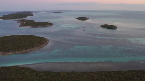 Drone Aerial View of Lonely Sailing Boat in Caribbean Sea Between Small Islands at Twilight