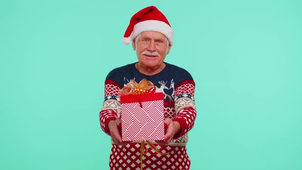 Senior Grandfather in New Year Sweater and Hat Presenting Christmas Gift Box Shopping Sale Holidays