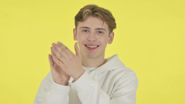 Young Man Clapping Applauding on Yellow Background