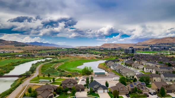 Dramatic cloudscape above a suburban area and golf course - aerial hyper lapse