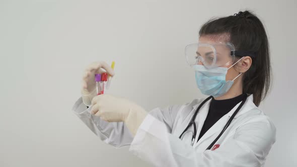 Doctor with Face Mask and Protective Glasses Working with SARS-CoV-2 in Laboratory. COVID-19