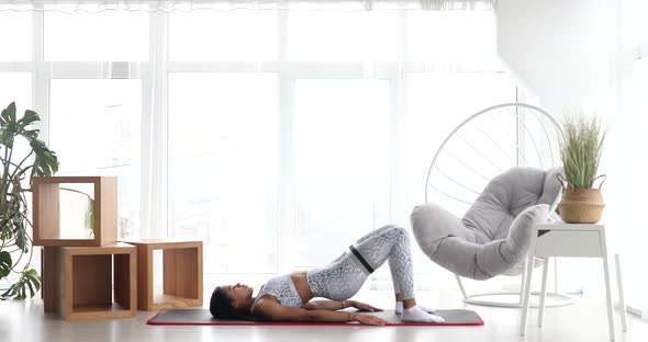 Athletic fit girl doing fitness aerobic exercises for booty in living room.