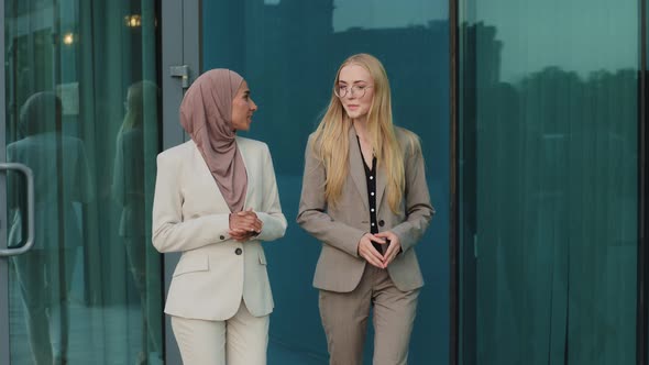 Indian Girl in Hijab Consults with Colleague Young European Woman During Office Break