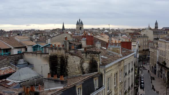 City of Bordeaux France rooftops showing Cailhau City Gate and pigeon flocks flying, Aerial pedestal