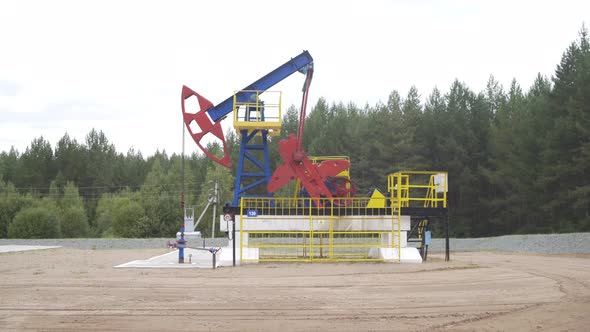 Well Pump Jack Operating. Drilling Rig Extract Crude Oil. Oil Mining Machine Pumping Crude Oil for