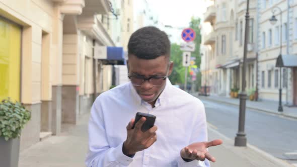 African Man Getting Angry on Call While Walking on the Street