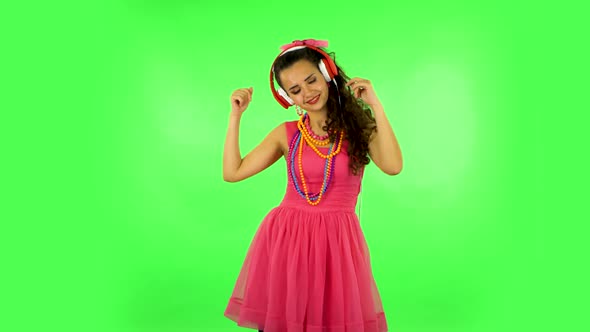 Girl Dancing and Singing in Big Red Headphones on Green Screen