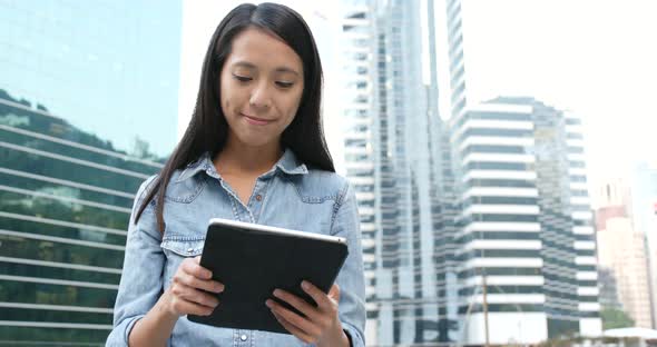 Woman looking at tablet in city