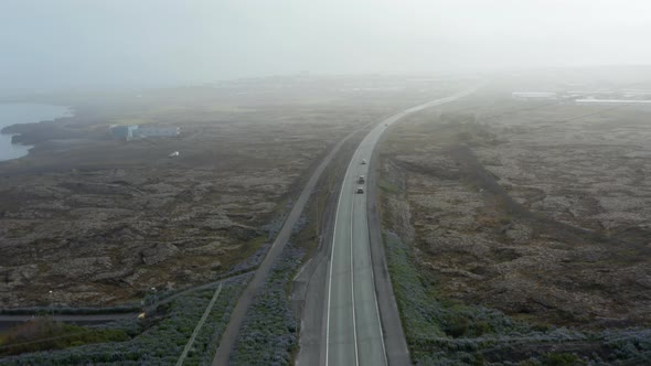 Forward Flight Aerial View Over Breathtaking and Surreal Icelandic Landscape with Car Driving on