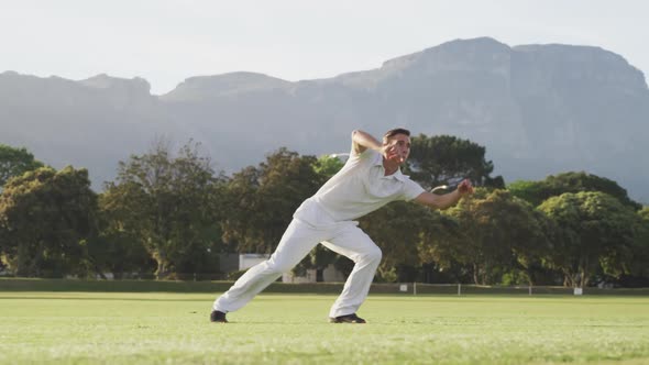 Cricket player catching the ball on the pitch