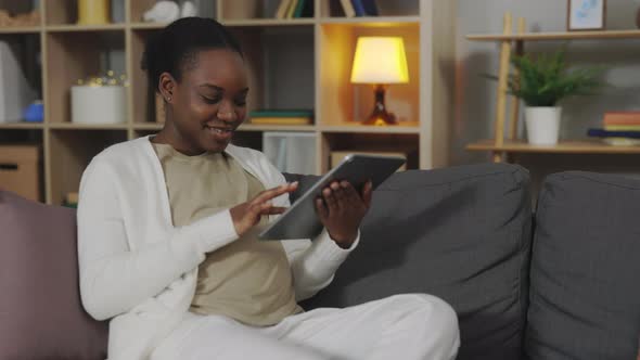 Pregnant African American Using Digital Tablet at Home