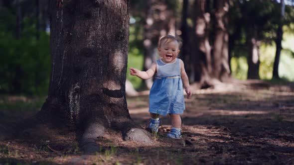 first steps of a one-year-old child in a forest or park