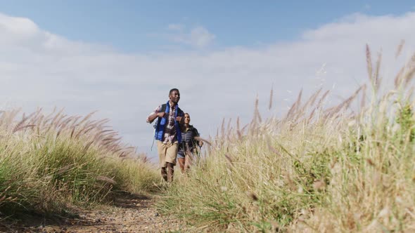 African american couple walking while trekking in the mountains