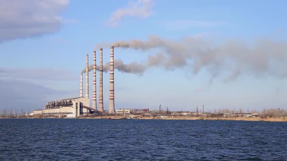 Factory Chimneys Smoke Against The Blue Sky