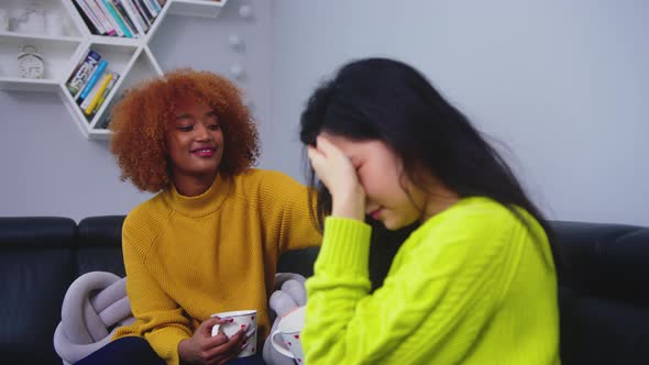 Shy Asian Woman Feeling Embarrassed, Putting Hand Over Her Head. African American Friend Cheering