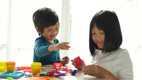 Asian Children Have A Fun Together With Colorful Modeling Clay At Home