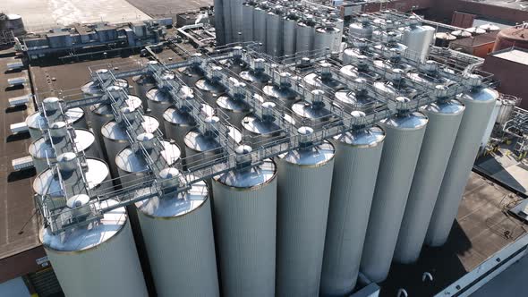 Stainless steel storage tanks for purification and fermentation of beer at USA brewery. Aerial view.