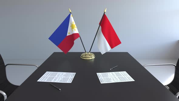 Flags of Philippines and Indonesia and Papers on the Table