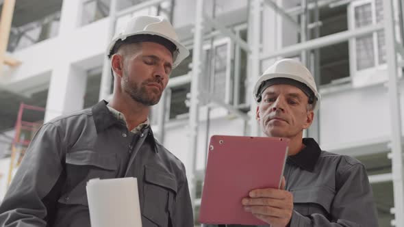 Caucasian Builders Using Tablet Computer