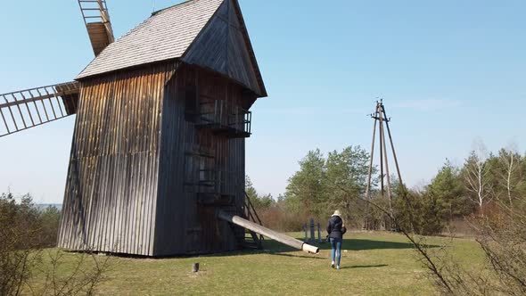 Woman Tourist Goes To the Traditional Old Poland Rustic Windmill