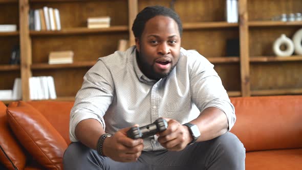 An AfricanAmerican Man with Joystick Playing Video Game