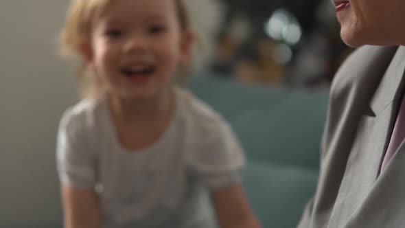 Happy Loving Senior Woman with Short Stylish Haircut Hugging Little Blond Boy While Sitting on Sofa