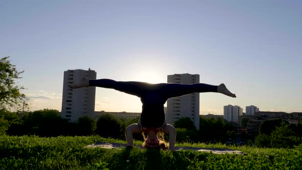 Young woman doing a handstand on viewpoint