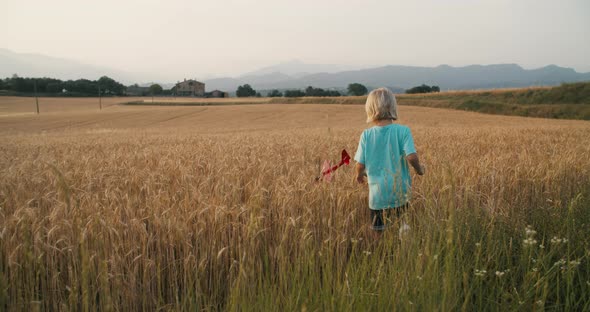 Children Playing with Toy Airplane on Wheat Field on Summertime Vacations