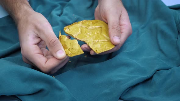 Man breaking caramel candy cookies made of sugar and soda.