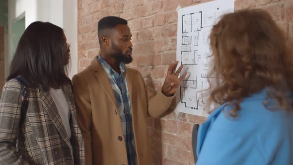 Interior Designer Discussing Apartment Renovation Idea with Happy Couple at Meeting