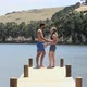 Affectionate couple walking down jetty towards lake - VideoHive Item for Sale