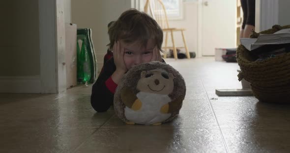 Kid playing peak a boo behind stuffed toy