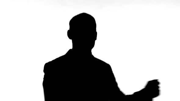 Silhouette of Man Dancing Against White Background