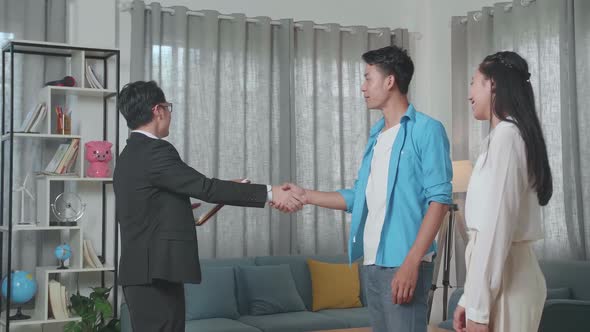 Asian Real Estate Agent Shaking Hands With A Man Who Walks Side By Side A Woman