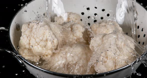 Water falling on Cauliflower, brassica oleracea, against Black Background, Slow Motion 4K