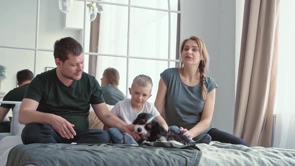 Loving Family and Little Son a Boy of European Appearance Sitting on a Bed in a Cozy Modern Room