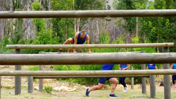 Fit people jumping over the hurdles during obstacle course 4k