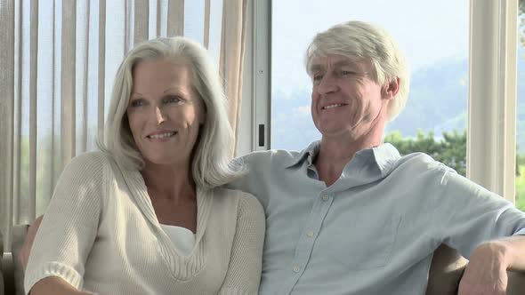 Mature couple watching television